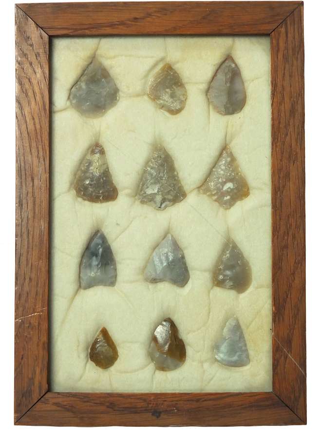 A framed group of 12 Neolithic flint arrowheads