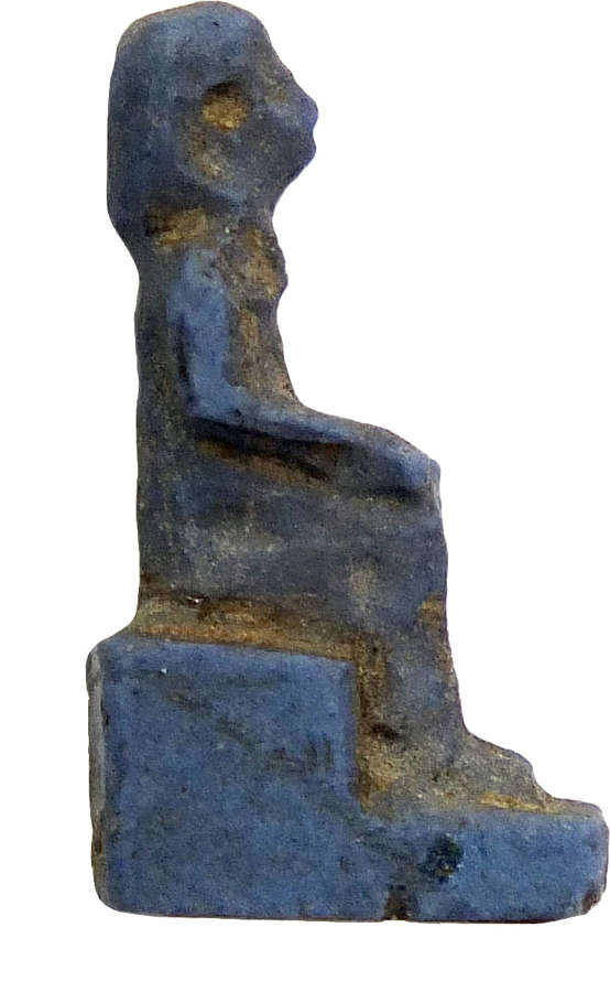 A small Egyptian glass amulet of a seated figure, c. 1550-1070 B.C.