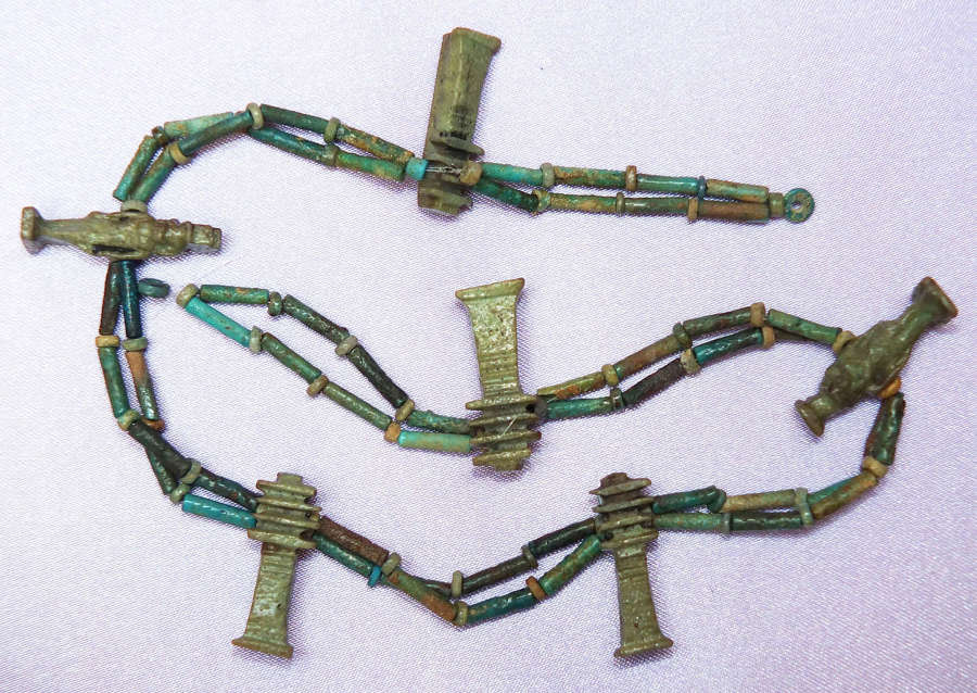 A double-stranded necklace of Egyptian faience beads with six amulets