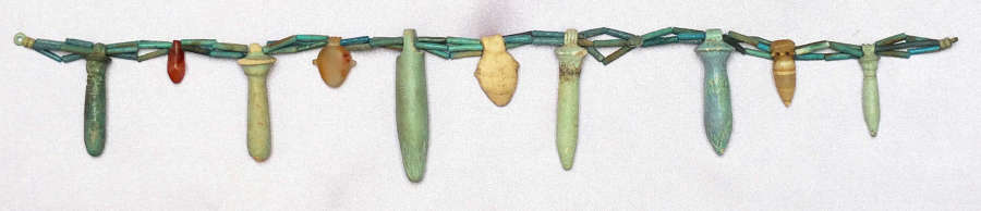 A triple-stranded necklace of Egyptian faience beads with ten amulets